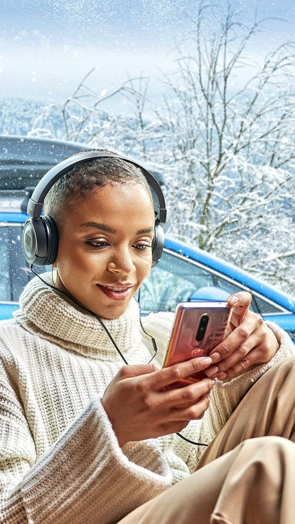 Senhora de fones dentro de casa com Škoda estacionado atrás