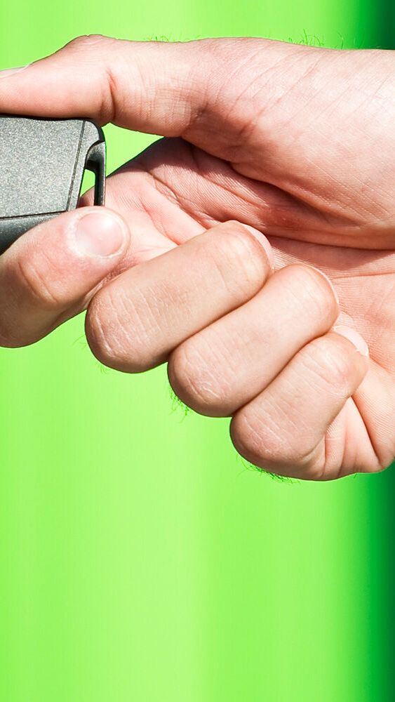 Grande plano de duas mãos onde é entregue uma chave de um Škoda 