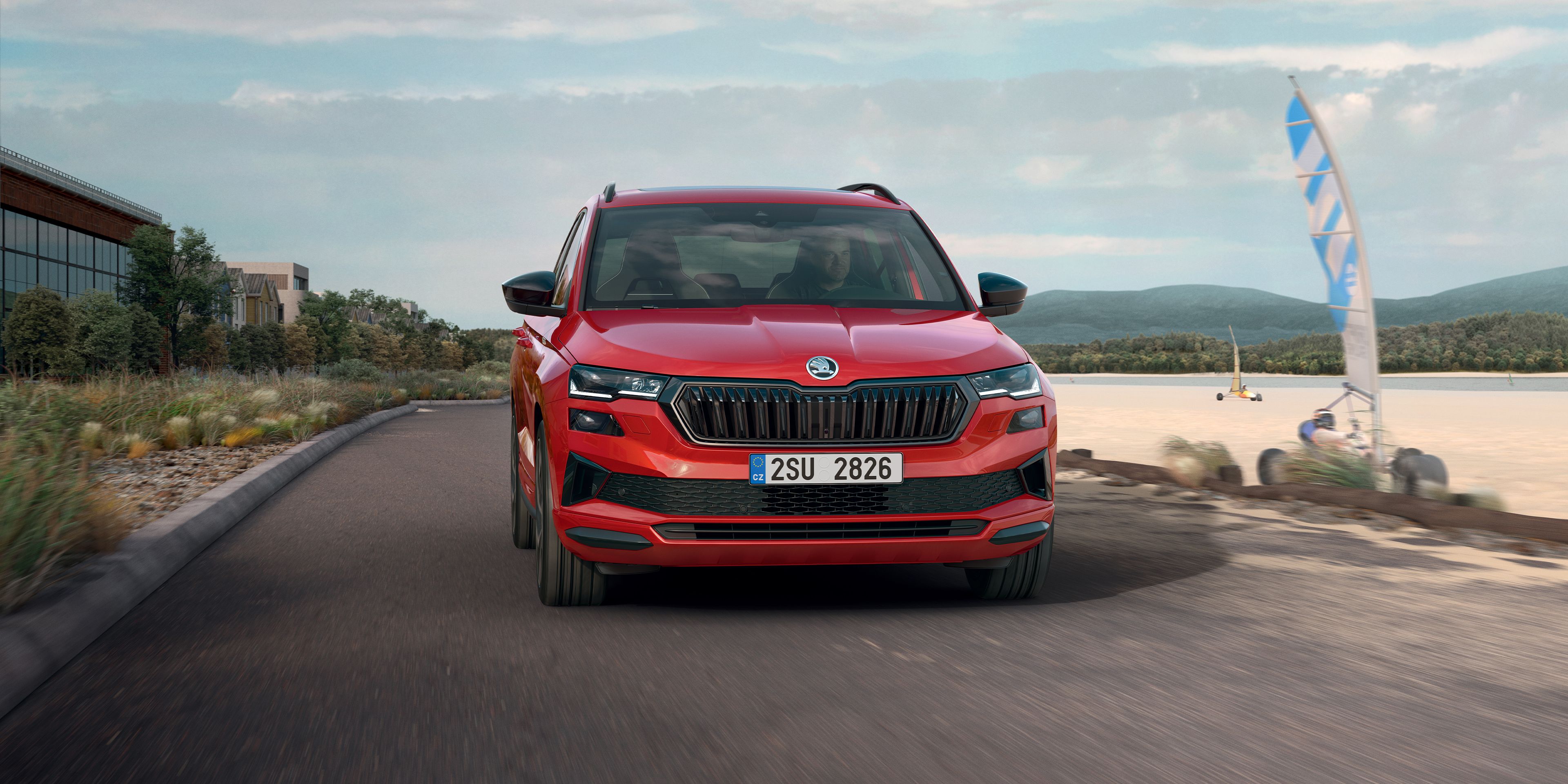 Zu sehen ist ein roter Škoda Karoq Sportline umgeben von Lichtern 