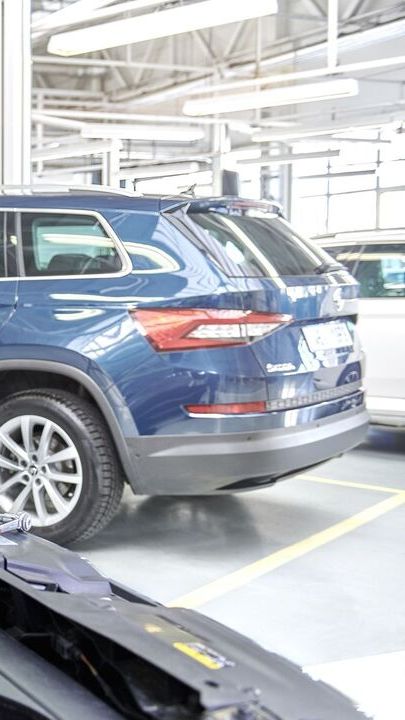 Ein Škoda Mechaniker beim Tausch der Starterbatterie.