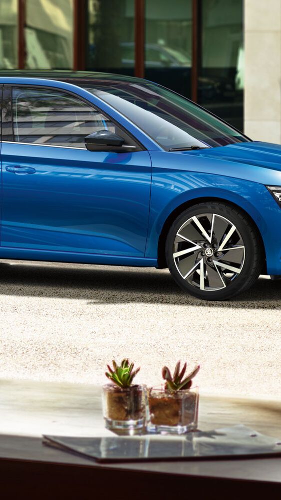 Škoda azul visto por um homem a partir de um café 
