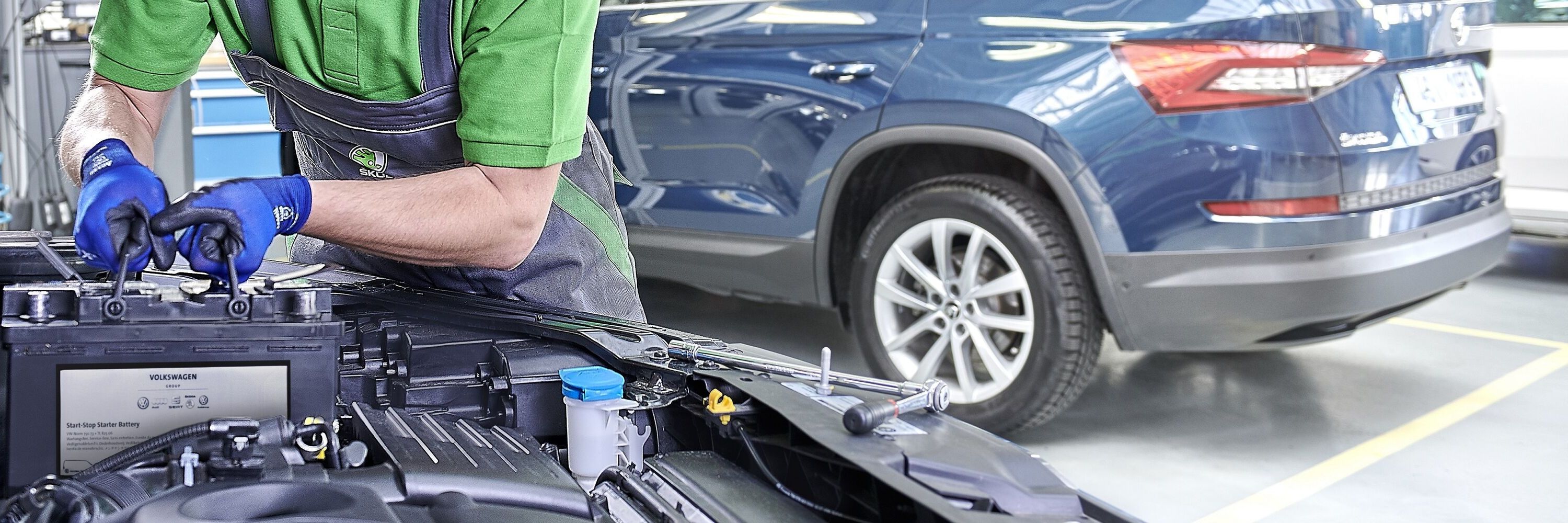 Ein Škoda Mechaniker wechselt die Batterie bei einem Škoda