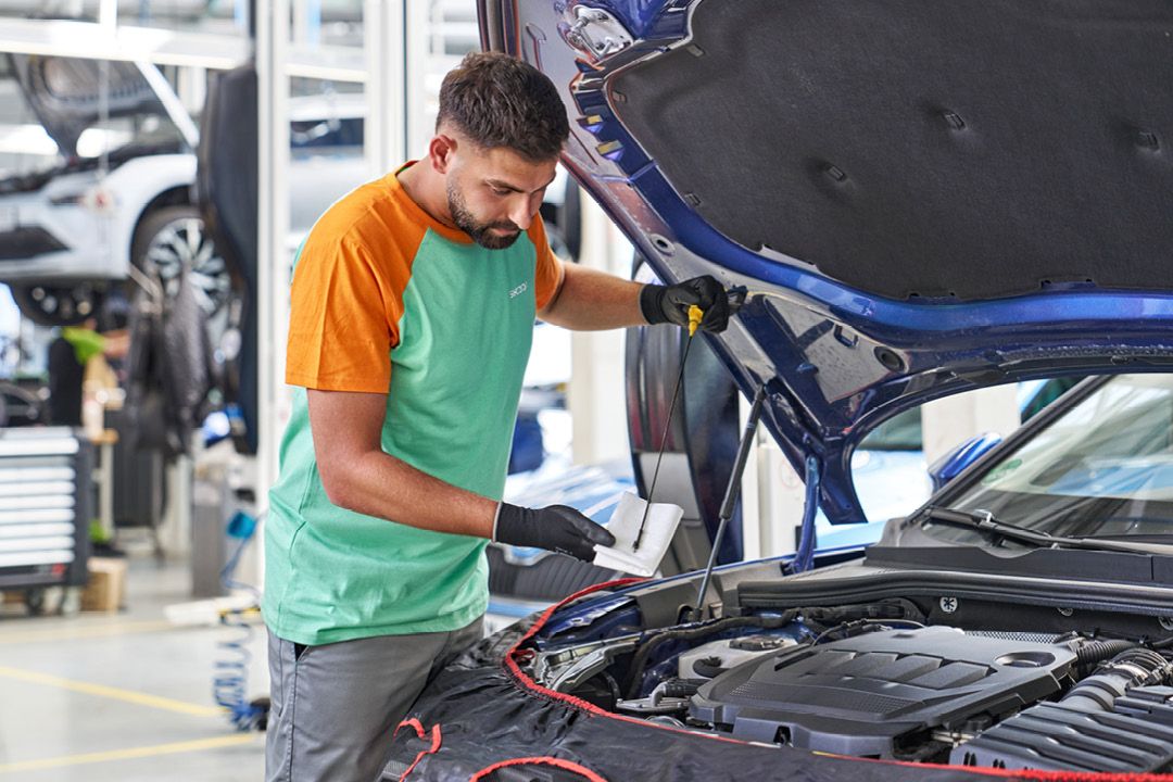 Ein Škoda Mechaniker überprüft den Ölstand bei einem Škoda.