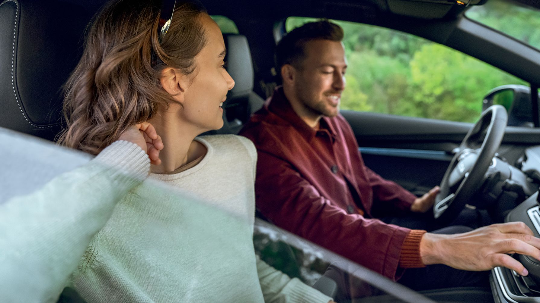 Ein Mann und eine Frau unterhalten sich während der Fahrt in ihrem Škoda.