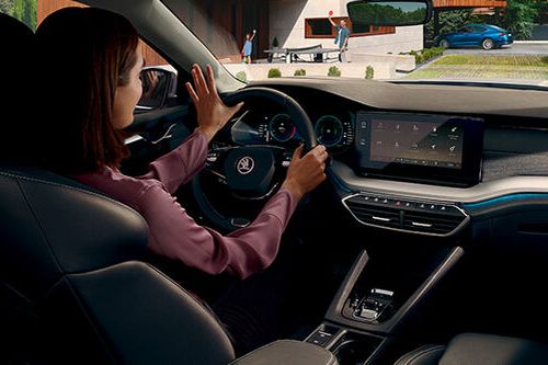 Uma mulher ao volante de um Škoda vista dos bancos traseiros 
